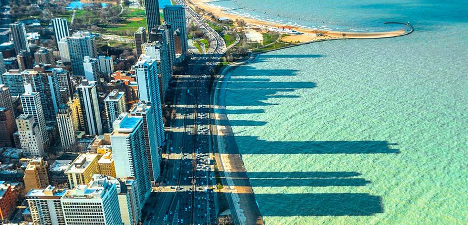 Chicago's Gold Coast with buildings casting shadows into the blue water on the coastline.